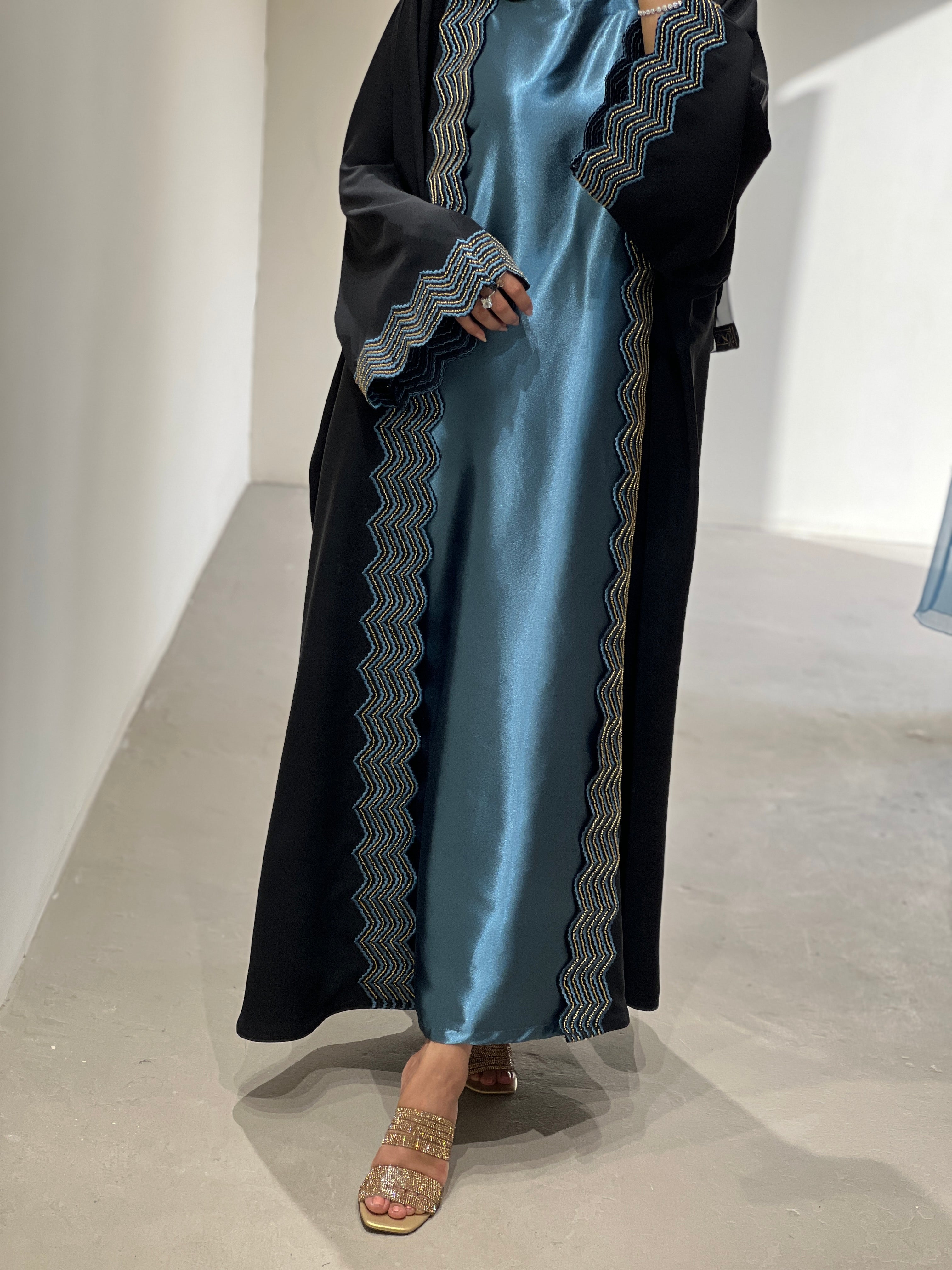 Elegant luxury abaya set with dress and sheila, featuring stylish zigzag detailing in a black and blue color scheme.